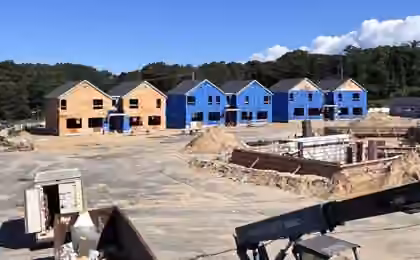 New construction site with multiple framed houses under construction