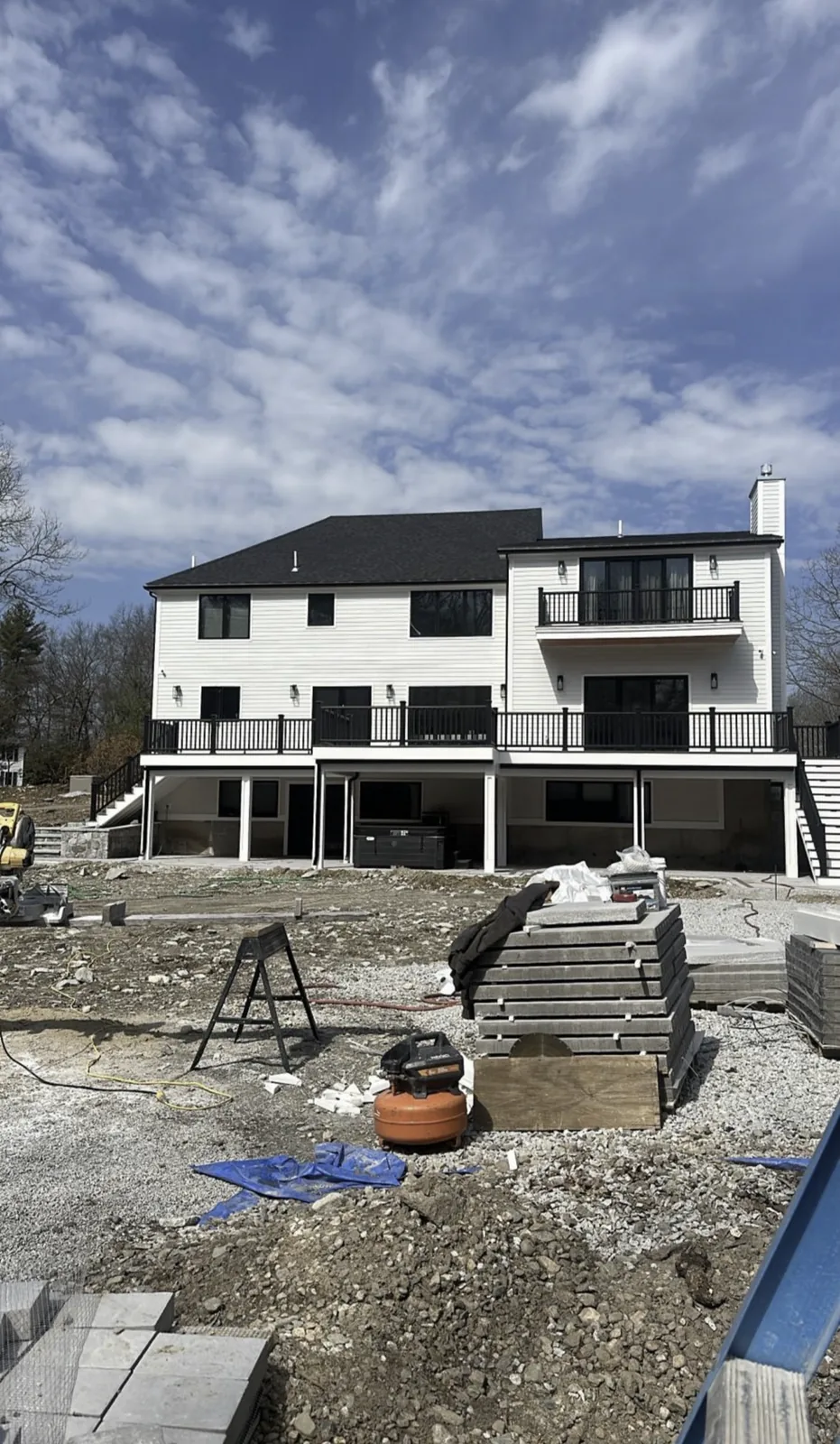 Completed two-story home addition with finished siding, windows and exterior stairs